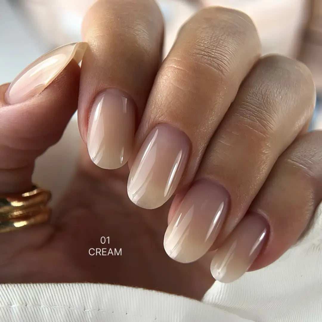 Close-up of a hand with beige nail polish on a neutral background