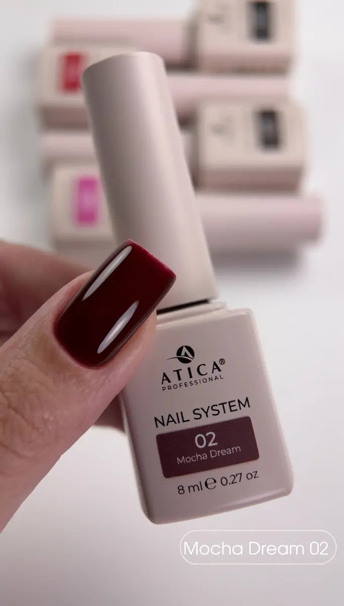 Atica nail polish bottle with a hand showing a dark red nail color.