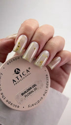 Hand with painted nails holding a container of Atica Professional builder gel.