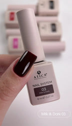 Atica nail polish bottle with a hand showing dark nail color