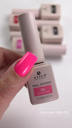 Atica nail polish bottle with a hand showing pink nail color against a blurred background