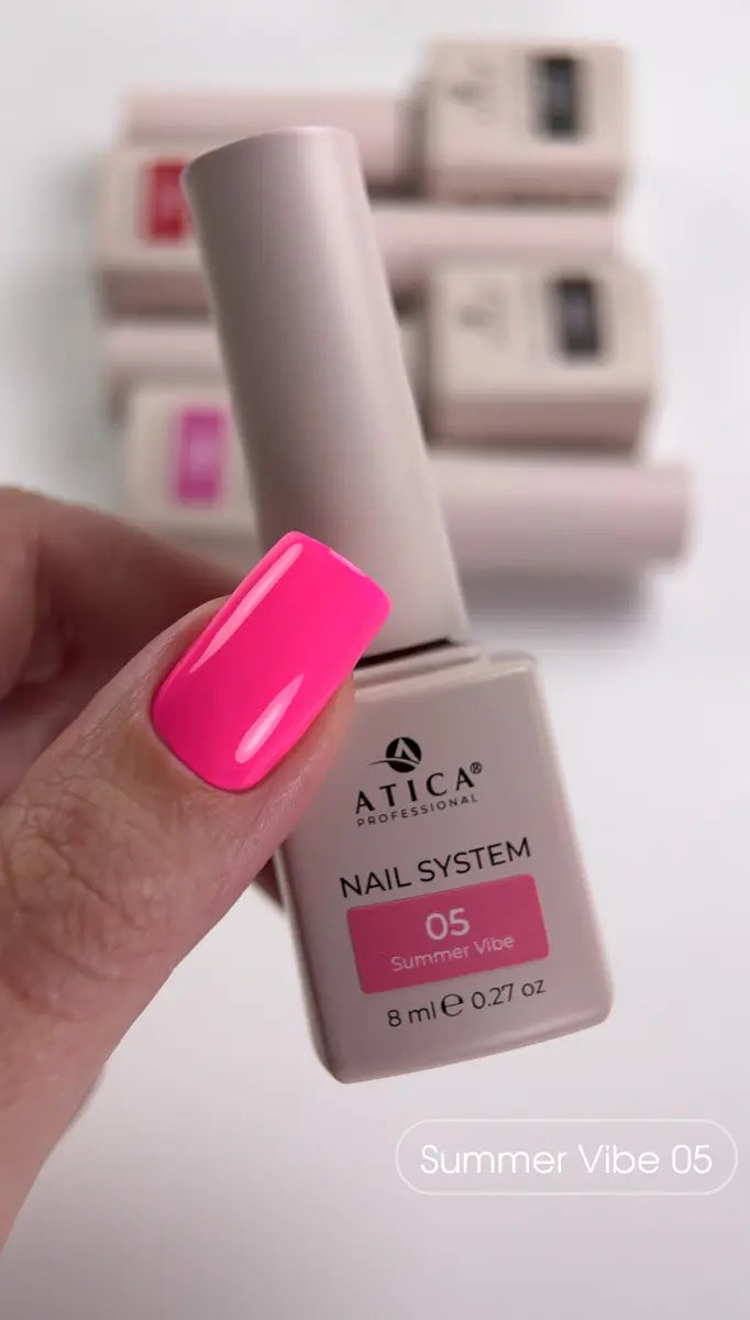 Atica nail polish bottle with a hand showing pink nail color against a blurred background
