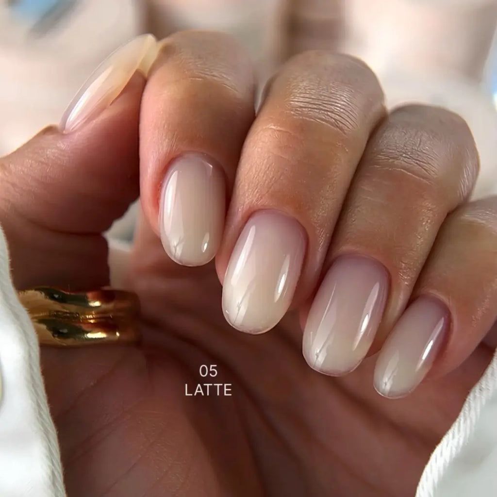 Hand with latte exel builder gel on a blurred background