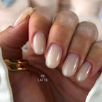Hand with latte exel builder gel on a blurred background