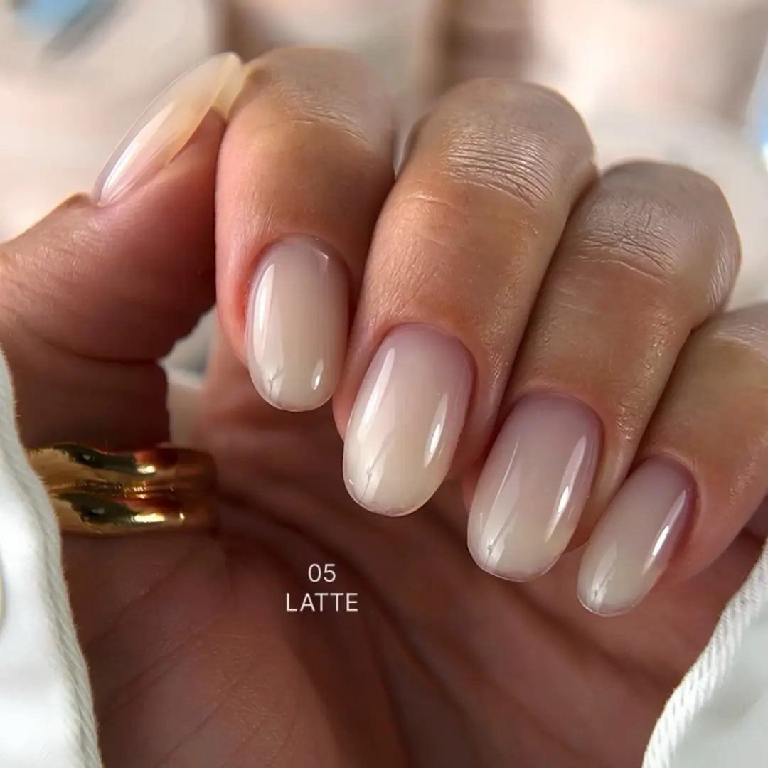 Hand with latte exel builder gel on a blurred background