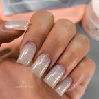 Close-up of a hand with glittery beige nail polish on a blurred background