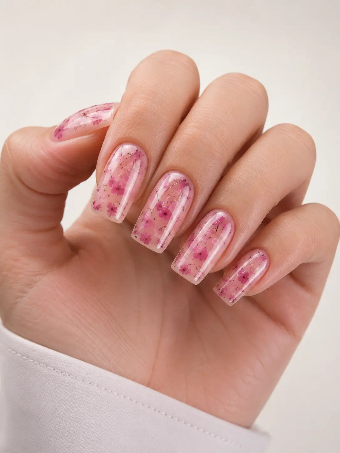 Closeup of Atica Builder Gel Floral 08 sculpting gel texture showing translucent pink base colour and delicate dried sakura flower petals