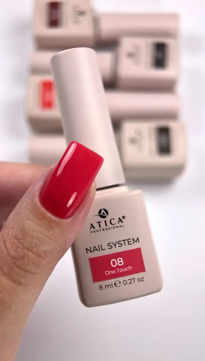 A hand with a glossy red manicured fingernail holds an 8 ml bottle of ATICA Professional Nail System shade 08 'One Touch' against a white background with blurred bottles in the background.