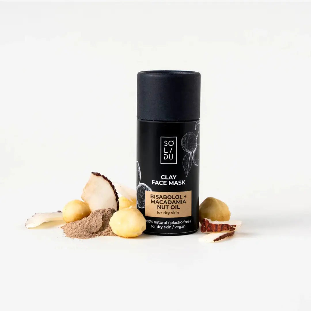 Clay face mask container with natural ingredients on a white background