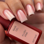 Nail polish with 'Flush Pink' color and 'Base Gel' text on a blurred background