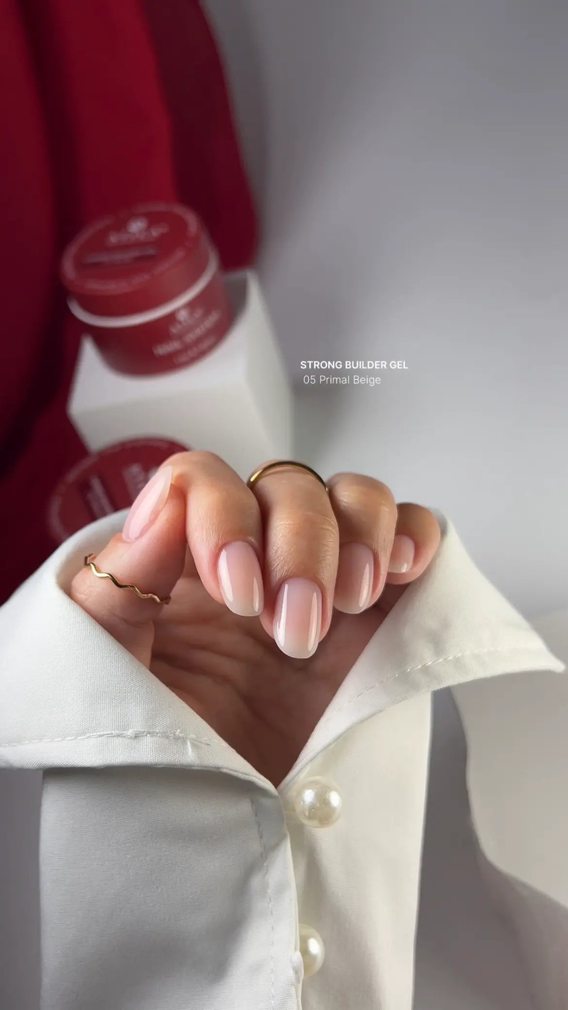 Close-up of a hand with a ring, blurred background with a bottle.