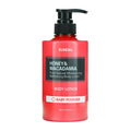 A 500 ml bottle of KUNDAL Honey & Macadamia Body Lotion in a vibrant red translucent plastic bottle with a black pump dispenser. The label features a black central block with white text and a white band at the bottom labeled 'BABY POWDER'.