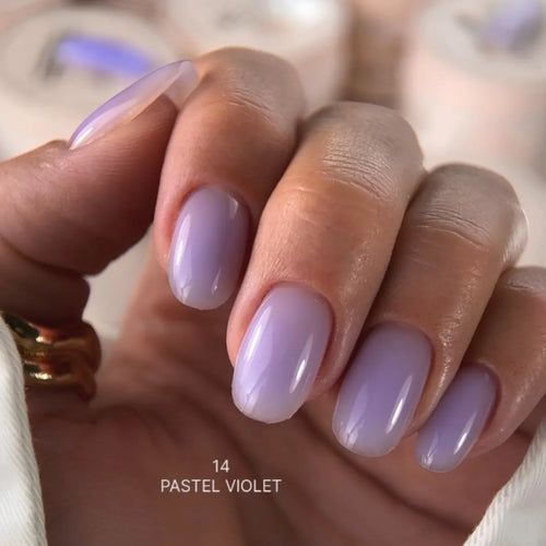 Hand with pastel violet nail polish on a blurred background