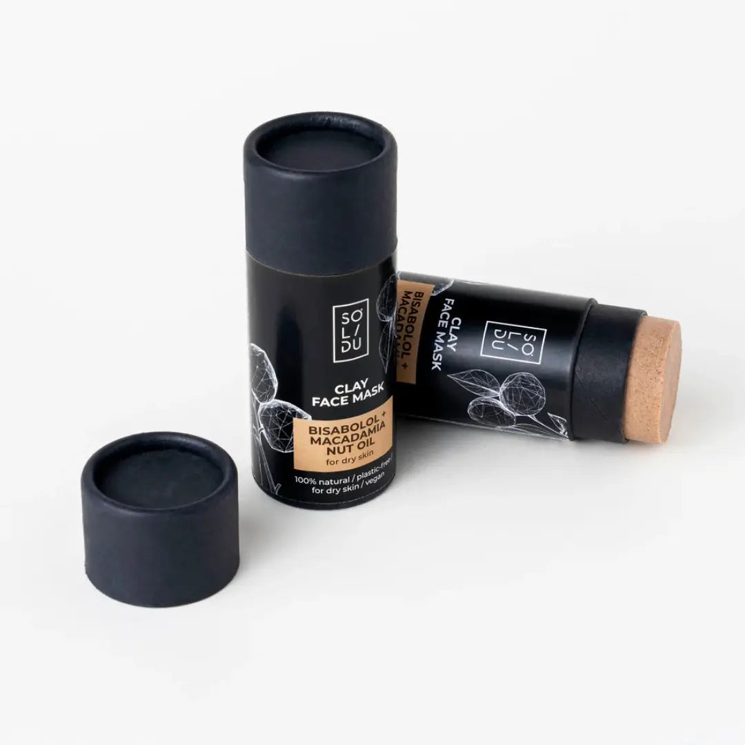 Two black clay face mask sticks with a white background