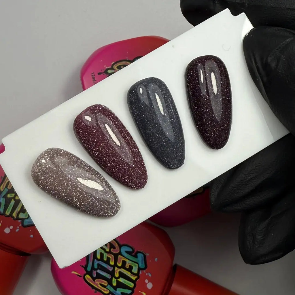 Set of three glittery nail samples on a white tray with a colorful background.