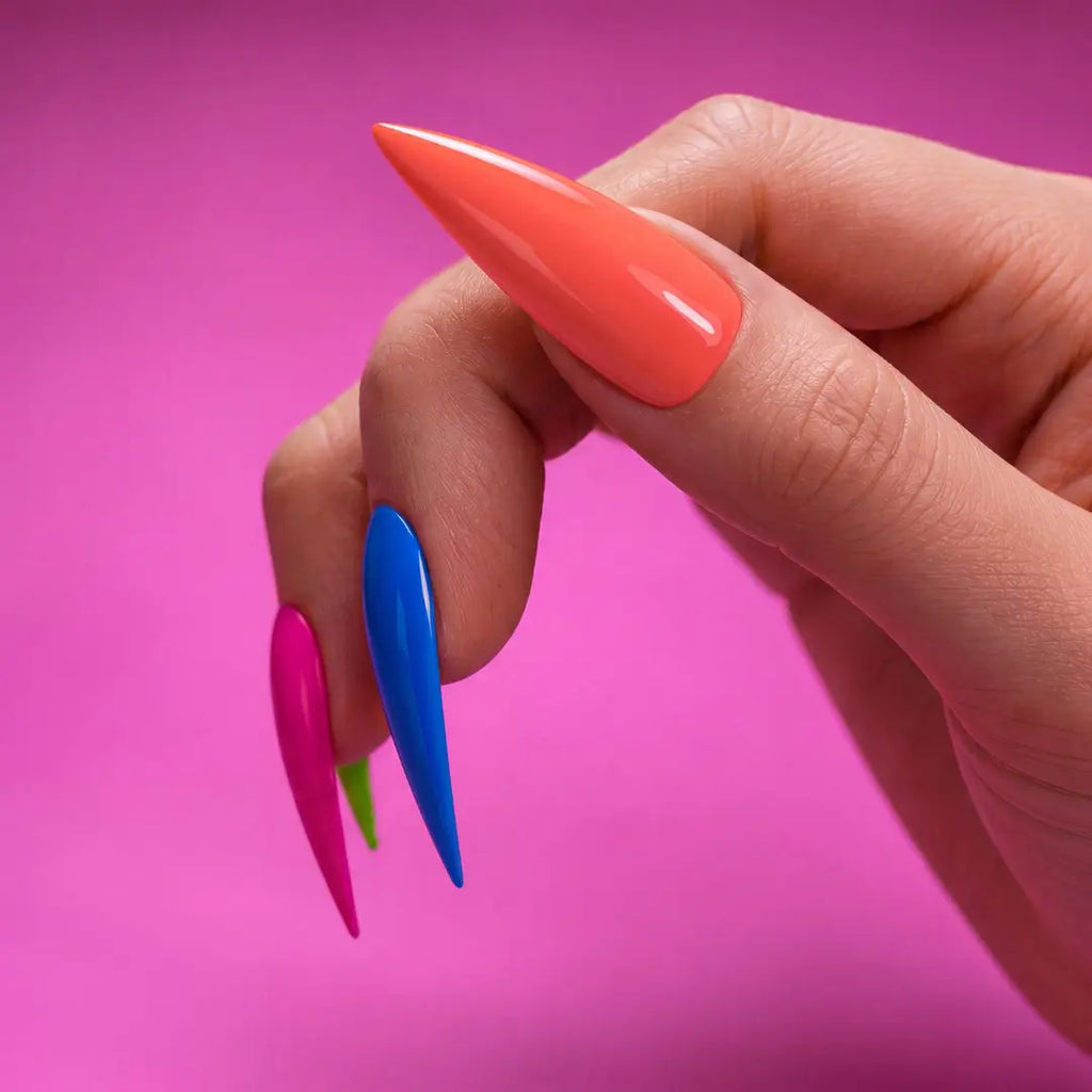 Hand with colorful stiletto nails against a pink background
