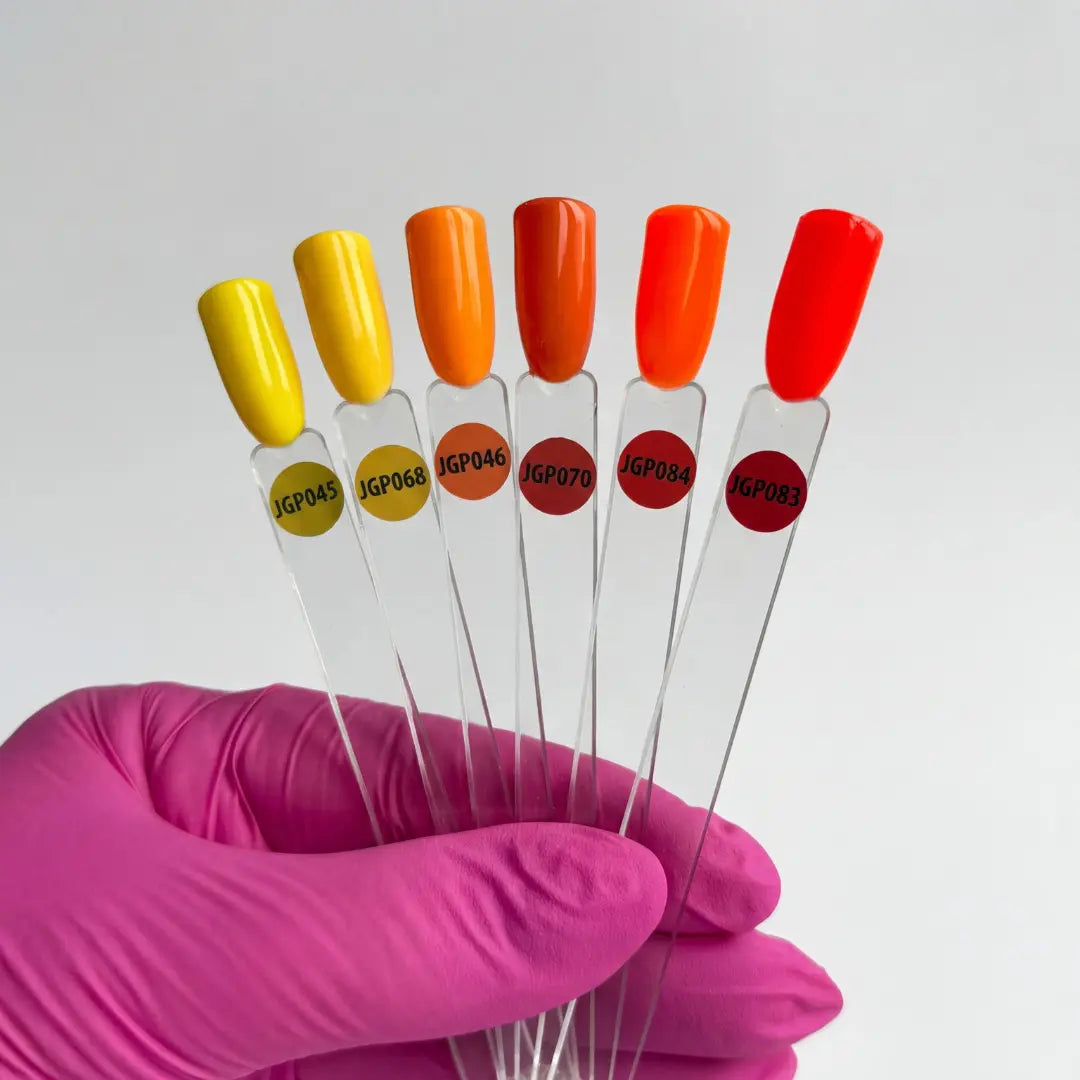 Set of test tubes with colored caps held by a gloved hand against a white background
