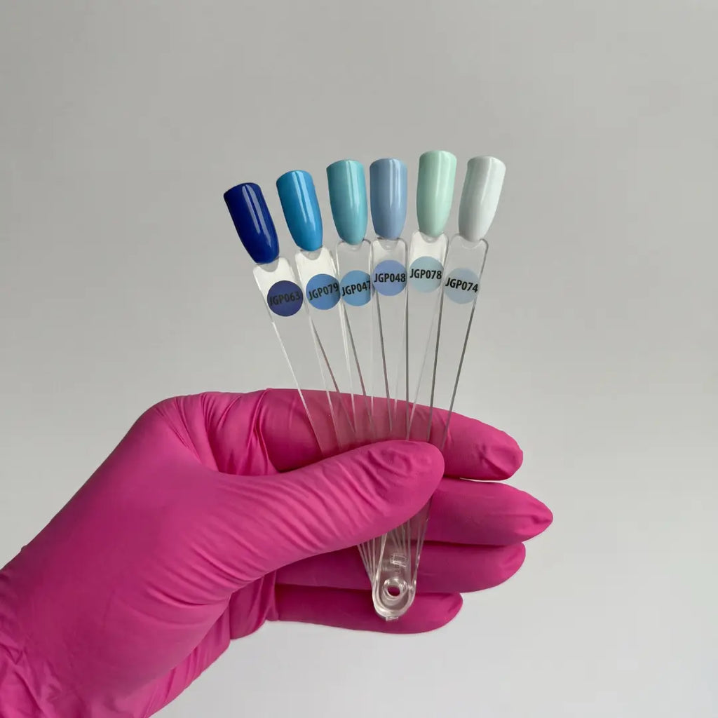 Hand holding six test tubes with colored caps against a gray background