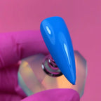 Close up of Jelly Gelly Blue Voltage gel polish applied on nail tip showing glossy texture