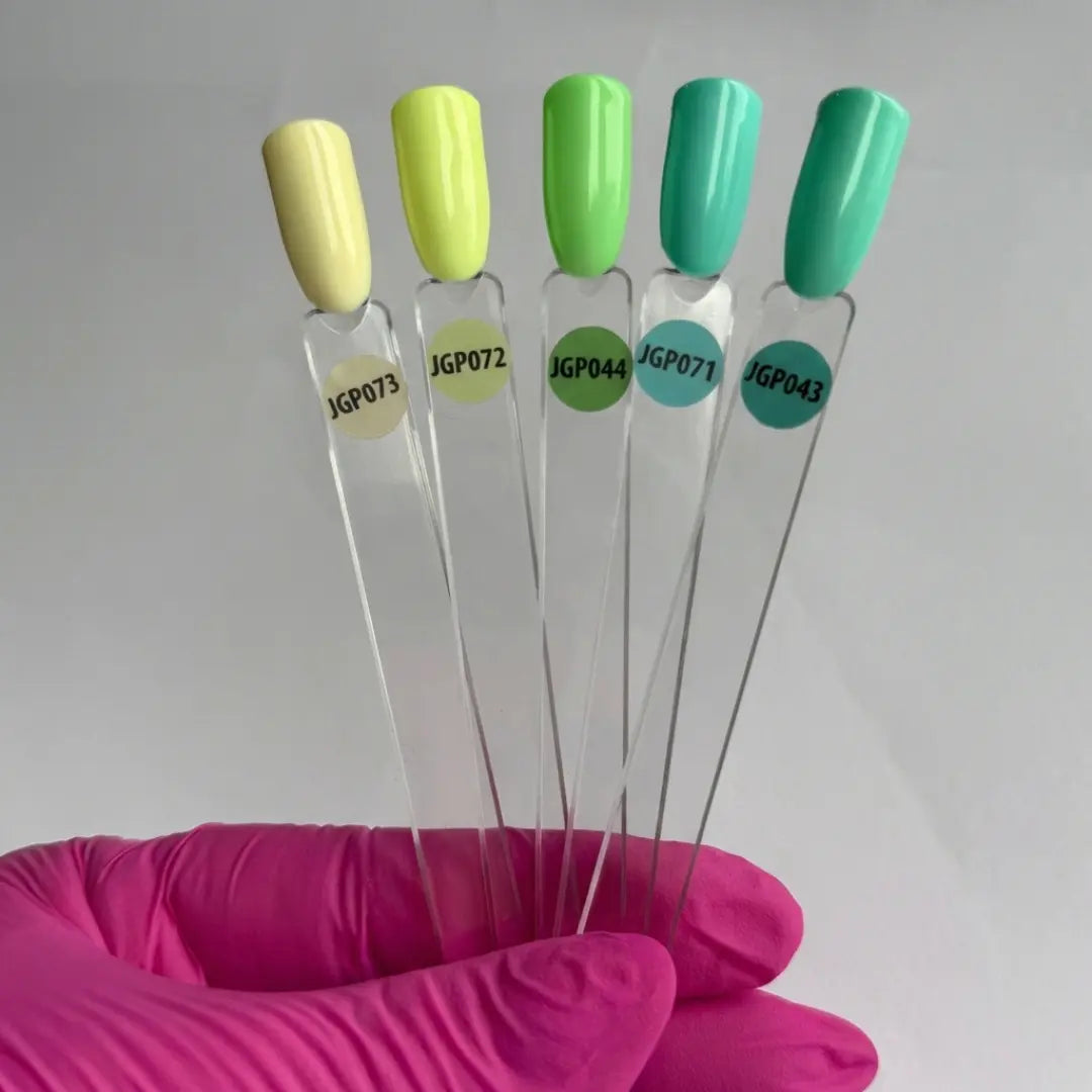 Set of five needles with colored handles held by a pink glove against a white background