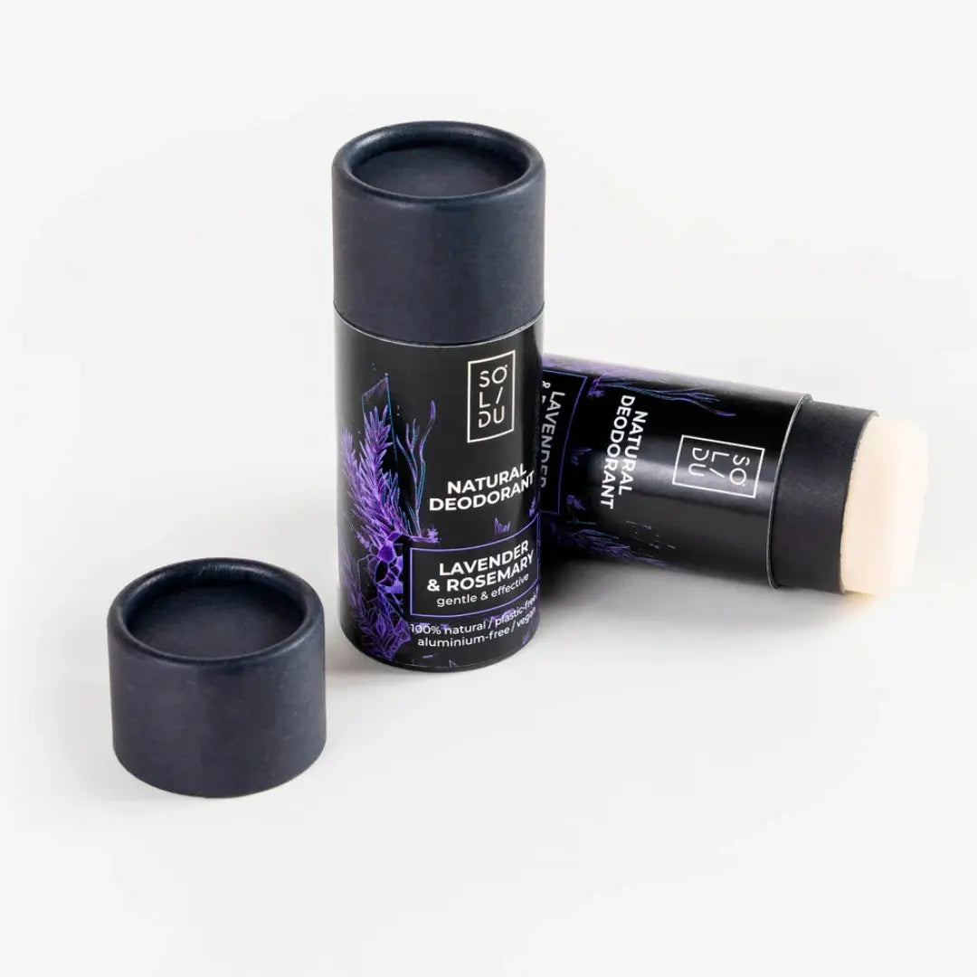 Two natural deodorants with a black container and white stick on a light gray background