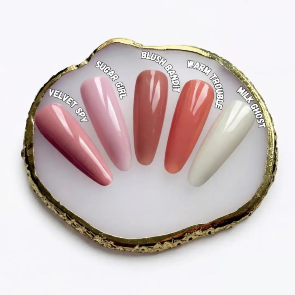 Set of false nails displayed on a shell with color names above each nail.